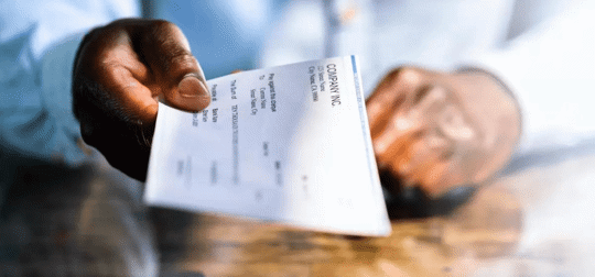 someone handing over a company pay check