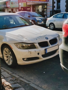 front of a white BMW after an accident